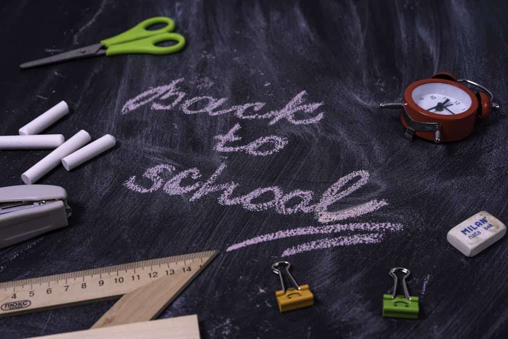 An arrangement of school supplies with 'back to school' written on a chalkboard.